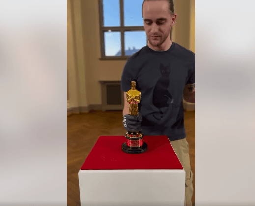 Rygos centre suspindo meninė katės instaliacija pirmajam šalies Oskarui paminėti. Youtube stop kadras